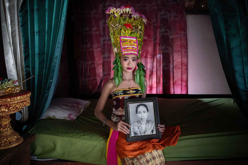 Cherished Memory Portrait of a young girl showing the image of her beloved grandmother © Roberto Pazzi