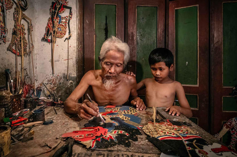 The Puppet Maker Portrait of an elderly puppet maker with his grandchild © Roberto Pazzi