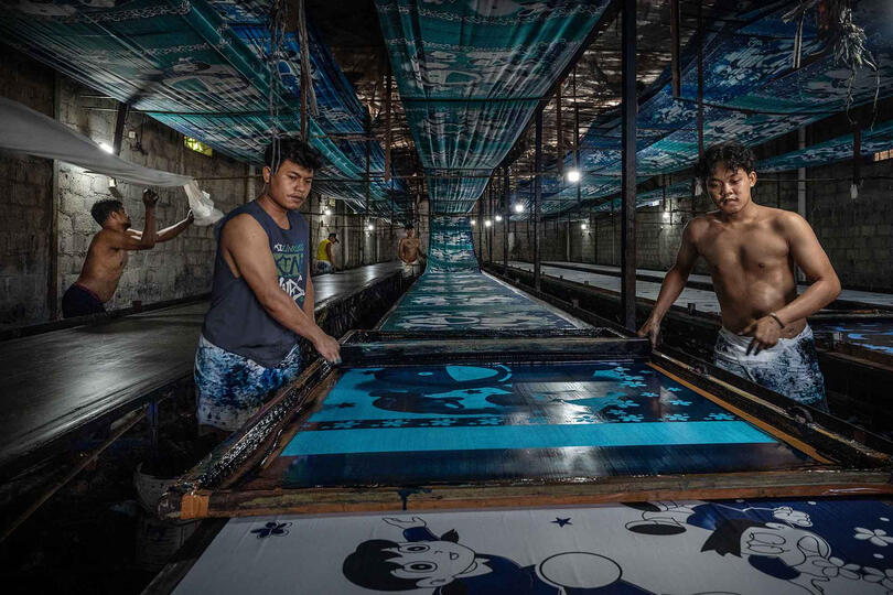 Batik Print Batik workers print fabrics using stamps to quickly apply repeating patterns © Roberto Pazzi