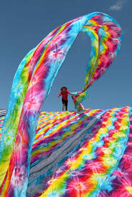The Rainbow Batik factory worker tossing fabric to dry in the sun © Roberto Pazzi