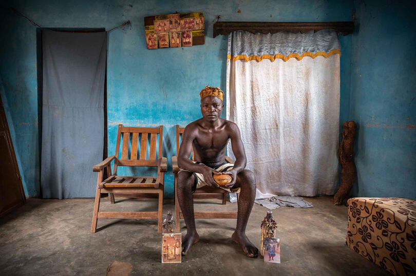 The Voice of the Ancestors Vodun believer with the images of his ancestors and the talismans used to communicate with their spirits © Roberto Pazzi