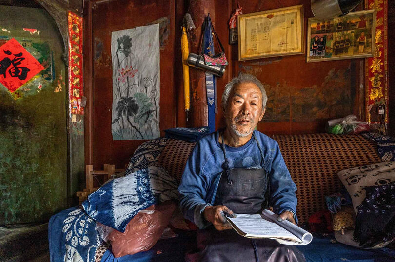 Bai Man Portrait of a Bai man working in his batik textile workshop © Roberto Pazzi