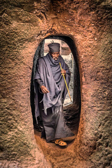 Tunnel of Faith Portrait of an Orthodox priest entering one of the eleven rock-hewn monolithic churches in Lalibela © Roberto Pazzi