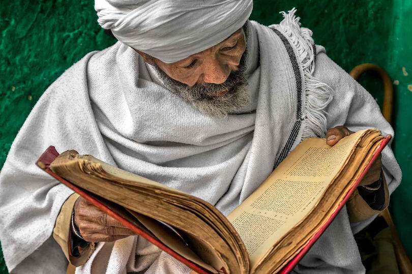 Sacred Text Portrait of an Orthodox priest reading a holy book written in ge'ez alphabet Buy Print