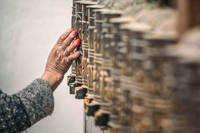 Wheels of Prayer Detail of a Buddhist devotee’s hand spinning a prayer wheel © Roberto Pazzi