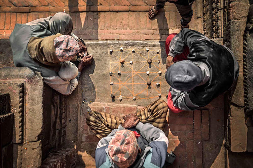 Baagh Chal Group of people playing "Baagh Chal" or "Moving Tigers", a typical Nepali street game © Roberto Pazzi
